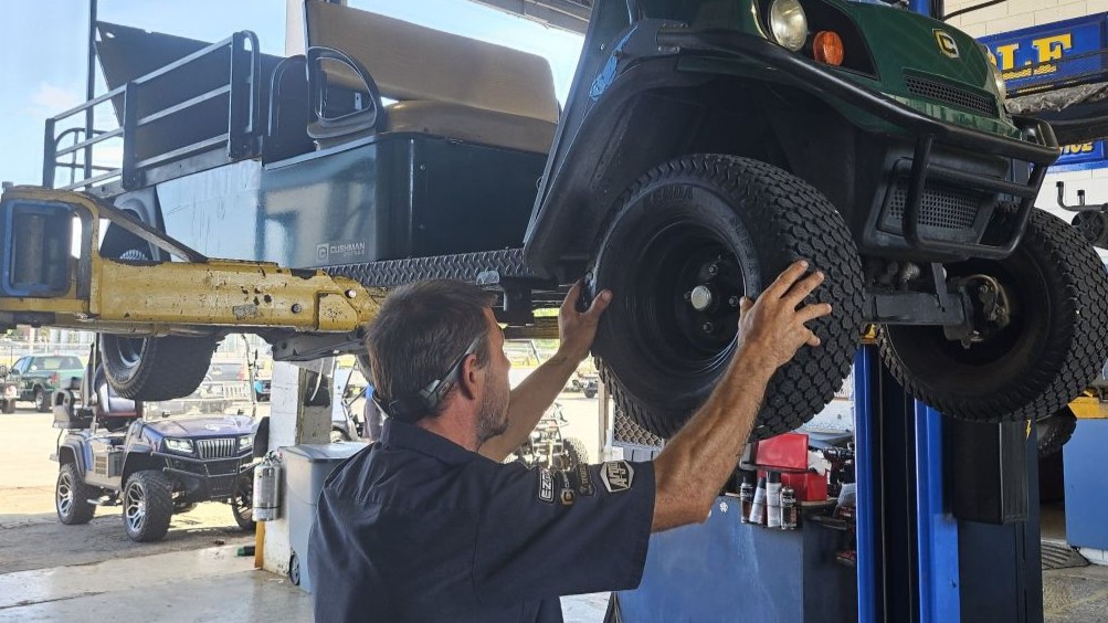 WilDar technician working on a golf cart on a lift